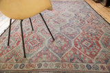 Vintage Jijim carpet's repeating lattice and rectilinear geometric patterns in faded tones.