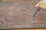 Vintage Jijim carpet's geometric lattice pattern in muted tones with dark secure end.