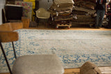 Vintage Tabriz carpet showing its soft antique ivory and blue covered field with ornate palmette motifs.