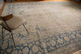 Lower left corner of vintage Tabriz carpet with ornate blue border and worn palmette field.