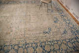 Tabriz carpet's worn beige field featuring blue ornate palmette and pinwheel motifs.