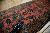 Soft raspberry red field, curvilinear slate blue floral motifs of a vintage Lilihan rug.