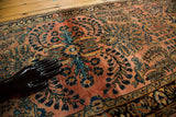 Close-up of the hand-knotted pile on a vintage Lilihan rug, showing floral sprays in navy blue on a dusty blush field.