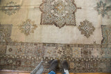 Vintage Oushak carpet border and muted serrated diamond shaped minor medallions.