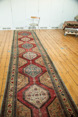 Detail of antique North West Persian runner: geometric medallions, ornate cherry red, teal borders.