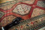Antique North West Persian runner's elaborate border featuring teal, red, and ivory geometric motifs.