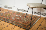 Intricate Karaja design featuring a geometric medallion and Laleh Abassi motifs in rust and green.