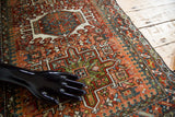 Intricate Karaja geometric pattern with green, rust, and ivory hooked motifs.