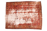 Antique distressed Heriz carpet, red, blue, and tan geometric design with exposed foundation.