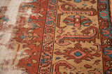 Distressed antique Heriz carpet showing heavy wear, rust tones, and visible foundation.