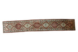Vintage Persian Serab runner with a chain of geometric latch-hook medallions in red, blue, and green.
