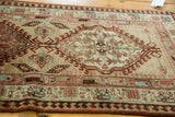 Geometric central medallion with latch hook border on a vintage Persian Serab rug runner.