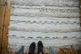 Alternating textured white rows of thick pile and plain weave with metal sequins.