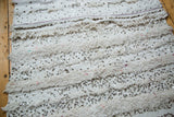 Cotton white Moroccan handira showcasing alternating textured weave and shimmering silver sequins.