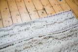 Alternating texture of cotton white wedding blanket with raspberry lines and silver sequins.