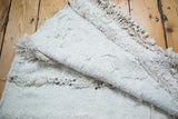 Cotton white wedding blanket with plain weave, thick pile, metal sequins, and shaggy fringe.