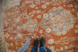 Vintage Oushak rug with rust orange field and time-softened slate blue and ivory floral motifs.