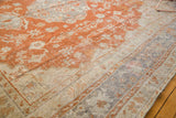 Vintage Oushak carpet corner with rust orange field, faded ivory florals, and slate border.