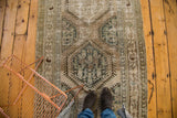 Vintage distressed Kars rug's central geometric medallion with antique ivory, celadon green, and coffee brown.