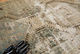 Distressed Kars runner texture, featuring ivory, sky blue, and coffee brown by a mannequin hand.