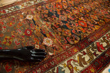 Distressed Malayer rug: intricate Herati pattern, detailed border, and abrash in rich, earthy colors.