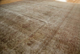 Distressed pile texture with faded floral patterns in antique ivory and wooded tones.