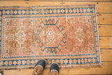 Peach, caramel, and sea blue geometric motifs on a vintage Karaja rug with boots.