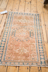 Vintage Karaja rug: geometric peach, caramel, and sea blue patterns on the secured edge.