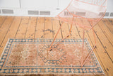 Vintage Karaja rug with geometric medallion and floral border in peach, caramel, sea blue.