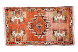 Vintage Oushak rug, serrated medallion and stylized plants on an abrashed rust red field.