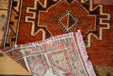 Hand-knotted reverse of a vintage Oushak rug with rust geometric pile and pink fringe.