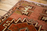 Vintage Oushak rug corner, showing rust red, ivory, and dark brown serrated geometric motifs.