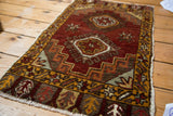 Copper, ivory, saffron plant motifs in prayer style panels with border and fringe.