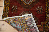 Folded corner of vintage Oushak rug reveals hand-knotted foundation, secure edges, and fringe.
