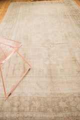 Vintage Oushak rug showing muted ivory, beige, and soft sage geometric-floral patterns.