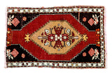 Vintage Oushak rug: gold scalloped medallion, floral arrangement, cherry red field, charcoal checkered corners.