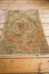 Visible fringe and hand-knotted pile of a vintage Oushak rug in beige and blanched terracotta.