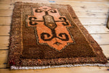 Tangerine orange rams horn design element and textured pile detail of vintage Oushak rug.
