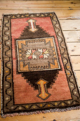 Angled view of blush Oushak rug, coffee brown framed medallion, serrated spandrels.