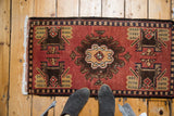 Vintage Oushak rug's brick red field with a bold central medallion and germinating plant motifs.