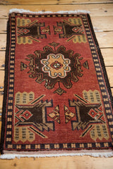 Vintage Oushak rug mat corner with brick red field, bold charcoal motifs, and ivory fringe.