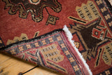 Vintage Oushak rug detail showing hand-knotted weave, secure black side, ivory fringe, and geometric border.