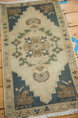 Shadow medallion with interlacing floral design and steel blue corner spandrels on vintage Oushak.