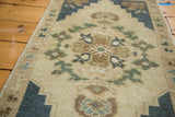 Vintage Oushak rug detail: Shadow medallion, interlacing florals, serrated spandrels in ivory, blue.