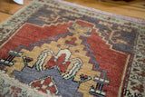 Hand-knotted Oushak rug's stepped geometric patterns in cherry red, slate blue, and pale mint.