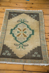 Vintage Oushak rug's white fringe and charcoal corner with teal chintamani triple dot design.