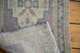 Vintage Oushak rug folded corner, showing hand-knotted back, secure fringe, and geometric pattern.