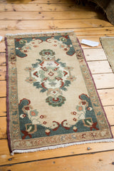 Hand-knotted vintage Oushak rug with teal scalloped corner spandrel and beige floral motifs.