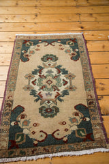 Vintage Oushak rug corner showing elegant scrolling teal and purple spandrels, soft fringe.