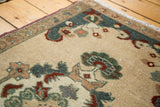 Scalloped corner spandrel of vintage Oushak rug with teal, sea foam green, and rust motifs.